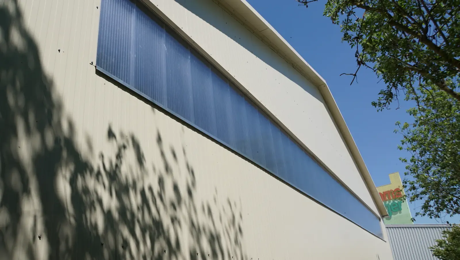 Fassade der hellen Lagerhalle von Oscorna mit Lichtband