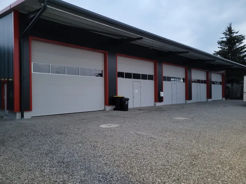 Anthrazitfarbene Systemhalle mit vier Sektionaltoren