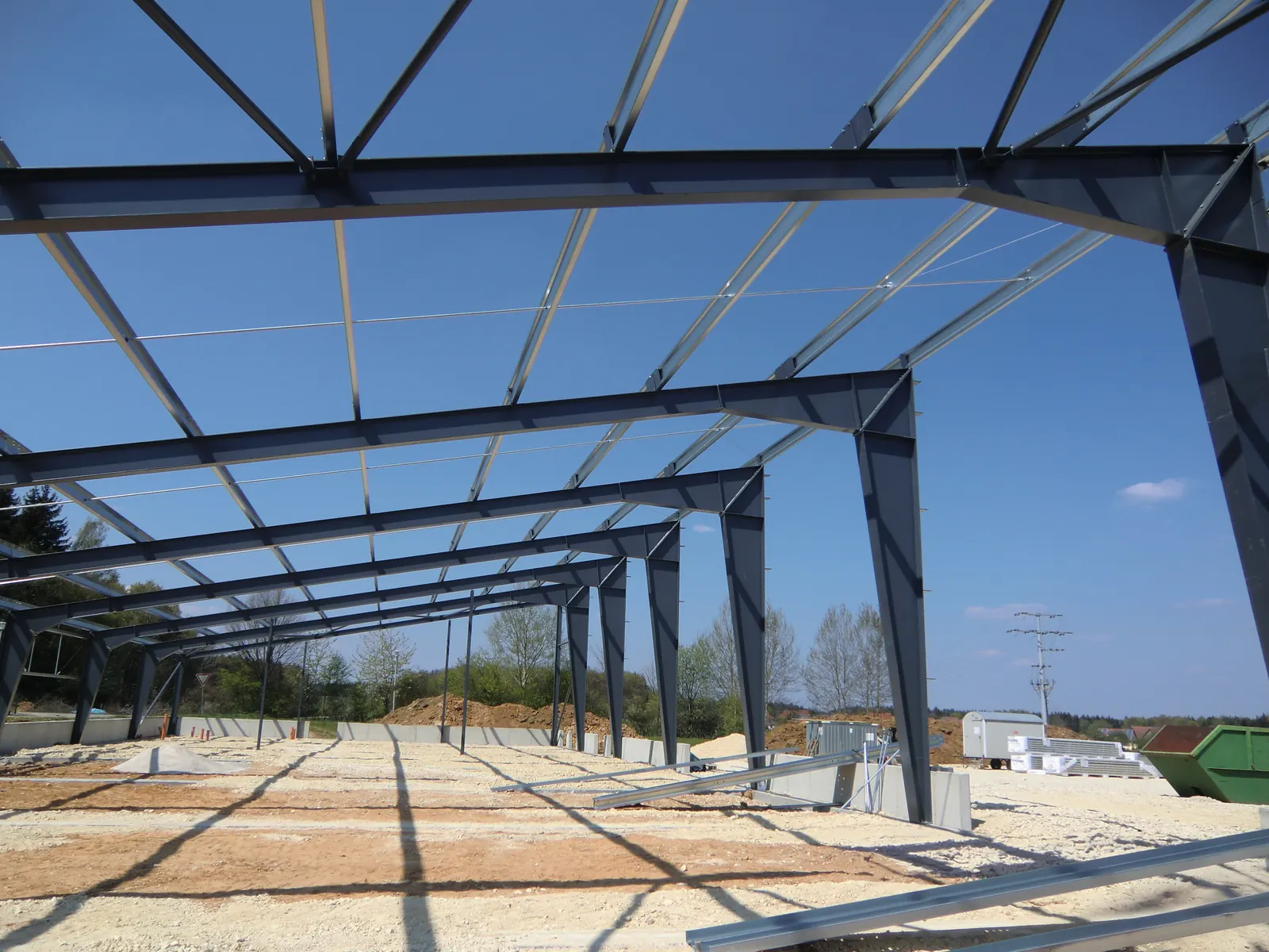 Stahlrahmen einer Systemhalle im Rohbau vor blauem Himmel